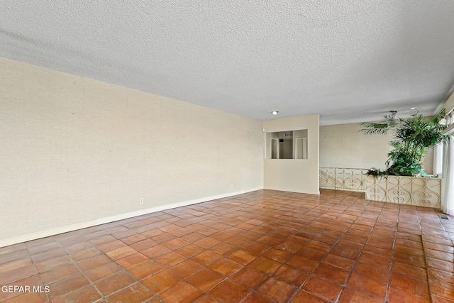 3134 Mesa Verde Ln, El Paso, TX 79904 - spare room featuring a textured ceiling, baseboards, and tile patterned flooring
