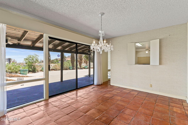 3134 Mesa Verde Ln, El Paso, TX 79904 - spare room with a ceiling fan, a chandelier, baseboards, a textured ceiling, and tile patterned flooring