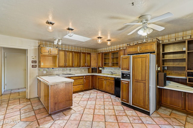 3134 Mesa Verde Ln, El Paso, TX 79904 - kitchen with high quality fridge, black dishwasher, brown cabinetry, open shelves, and light countertops