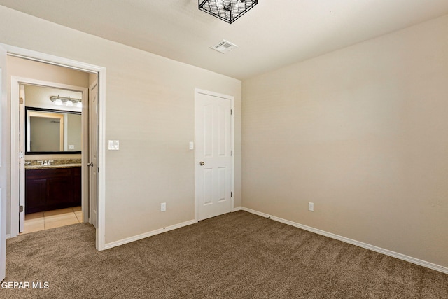 14840 Tim Hardaway, El Paso, TX 79938 - unfurnished bedroom featuring light carpet, baseboards, and ensuite bath