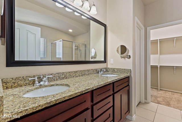14840 Tim Hardaway, El Paso, TX 79938 - bathroom featuring a shower stall, double vanity, tile patterned floors, and a walk in closet