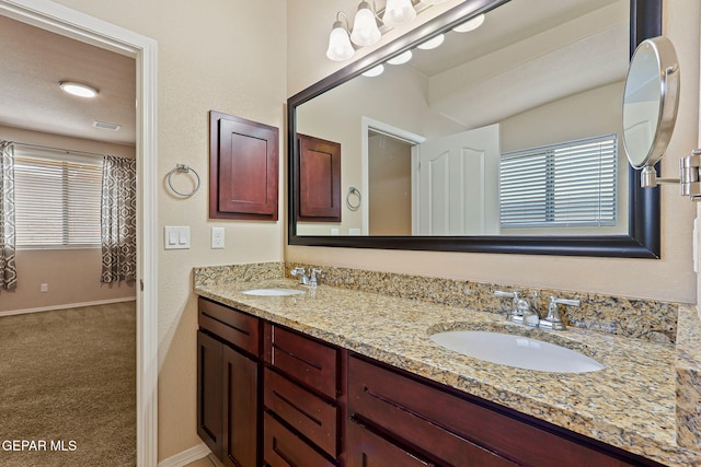 14840 Tim Hardaway, El Paso, TX 79938 - bathroom featuring double vanity and baseboards