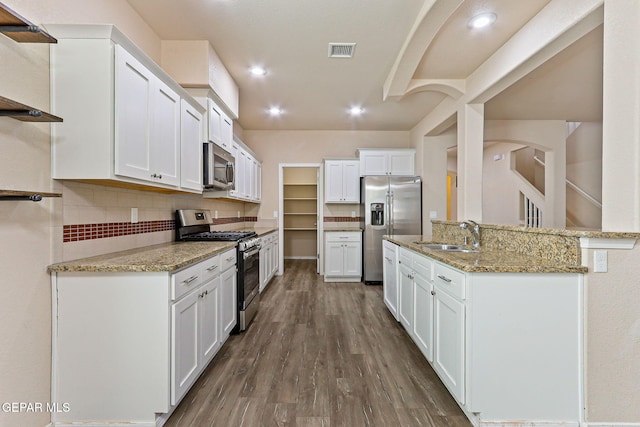 14840 Tim Hardaway, El Paso, TX 79938 - kitchen featuring stainless steel appliances, a sink, white cabinetry, backsplash, and dark wood finished floors