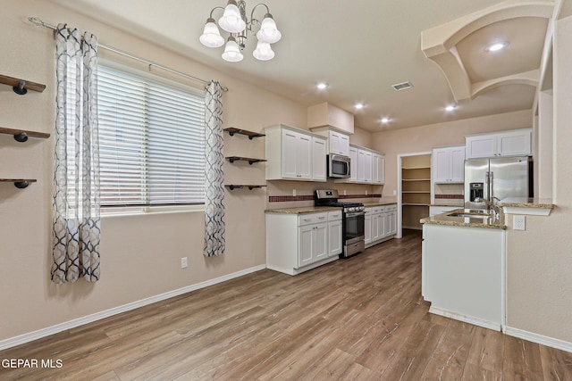 14840 Tim Hardaway, El Paso, TX 79938 - kitchen featuring stainless steel appliances, a sink, baseboards, white cabinetry, and wood finished floors