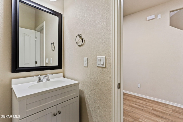 14840 Tim Hardaway, El Paso, TX 79938 - bathroom featuring wood finished floors, vanity, baseboards, and a textured wall