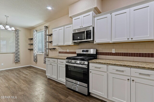 14840 Tim Hardaway, El Paso, TX 79938 - kitchen featuring stainless steel appliances, backsplash, baseboards, white cabinets, and a textured ceiling