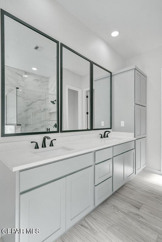 248 Emerald Storm Pl, El Paso, TX 79928 - bathroom featuring double vanity and a marble finish shower