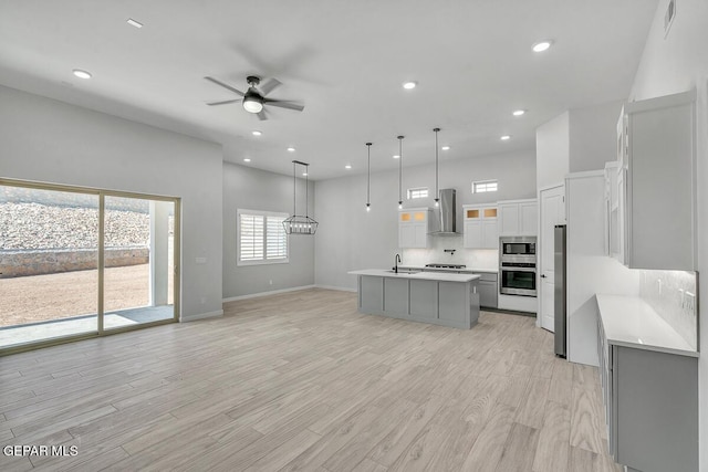 248 Emerald Storm Pl, El Paso, TX 79928 - kitchen with a sink, light countertops, ceiling fan, decorative backsplash, and wall chimney range hood