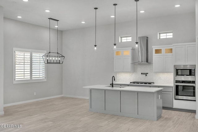 248 Emerald Storm Pl, El Paso, TX 79928 - kitchen featuring wall chimney exhaust hood, stainless steel appliances, a sink, light countertops, and tasteful backsplash