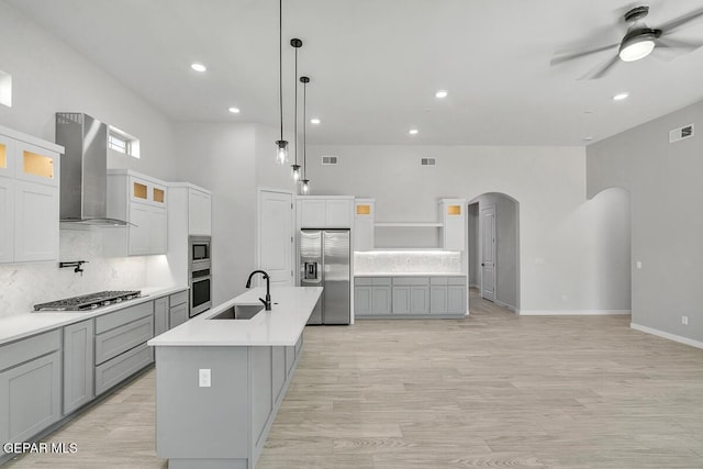 248 Emerald Storm Pl, El Paso, TX 79928 - kitchen featuring appliances with stainless steel finishes, wall chimney range hood, arched walkways, a sink, and ceiling fan