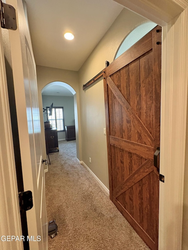 12217 Chapel Hill Rd, El Paso, TX 79928 - hallway featuring carpet floors, arched walkways, a barn door, and recessed lighting