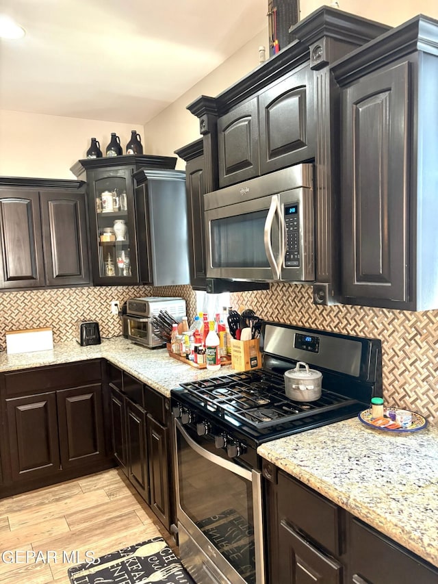 12217 Chapel Hill Rd, El Paso, TX 79928 - kitchen featuring stainless steel appliances, backsplash, glass insert cabinets, and light stone countertops