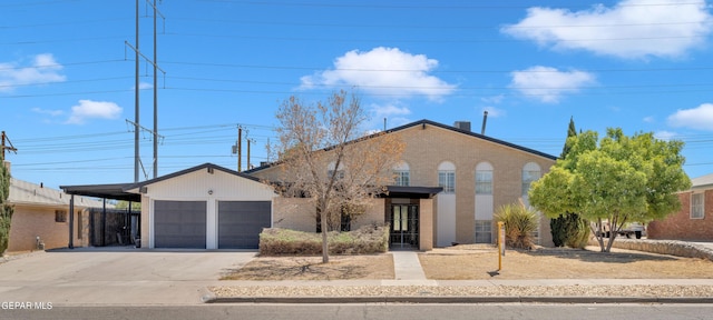 1460 Backus St, El Paso, TX 79925 - view of front of house with concrete driveway, brick siding, an attached garage, and a carport