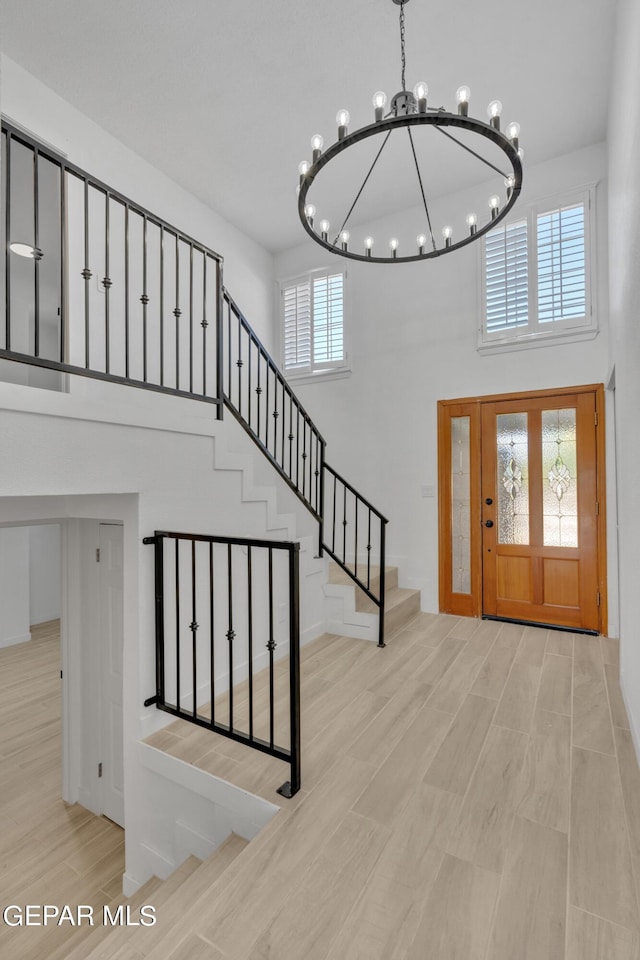 1460 Backus St, El Paso, TX 79925 - entrance foyer with a towering ceiling, a chandelier, stairs, wood finished floors, and healthy amount of natural light