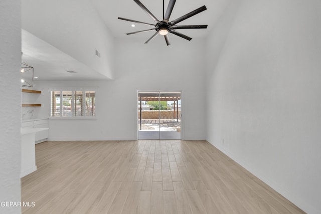 1460 Backus St, El Paso, TX 79925 - unfurnished living room featuring a towering ceiling, light wood-style flooring, healthy amount of natural light, ceiling fan, and baseboards