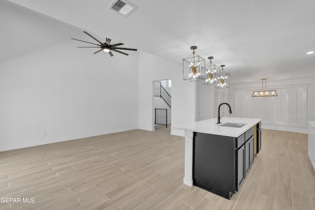 1460 Backus St, El Paso, TX 79925 - kitchen with a sink, light countertops, a chandelier, light wood-style flooring, and an island with sink