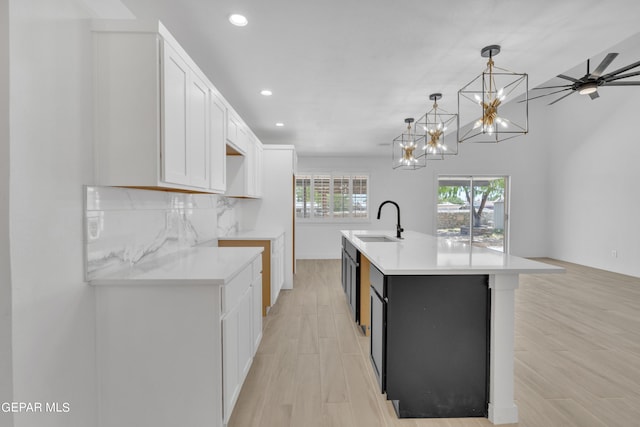 1460 Backus St, El Paso, TX 79925 - kitchen with a sink, recessed lighting, white cabinetry, an island with sink, and light wood-style floors