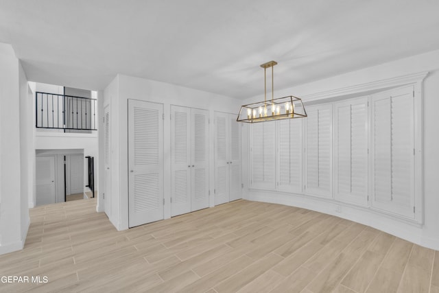 1460 Backus St, El Paso, TX 79925 - unfurnished dining area featuring light wood-type flooring, a chandelier, and baseboards