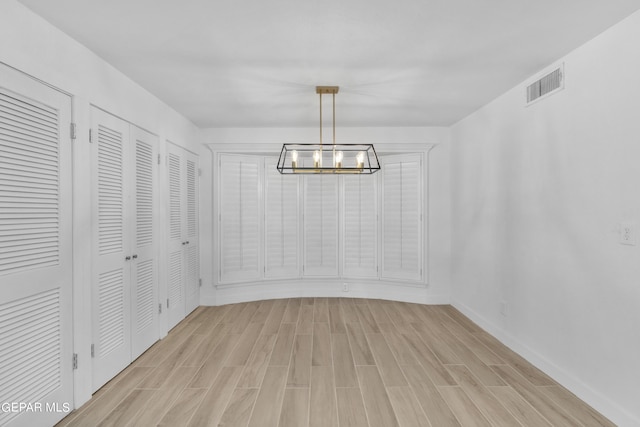 1460 Backus St, El Paso, TX 79925 - unfurnished dining area with a chandelier, light wood-type flooring, and baseboards