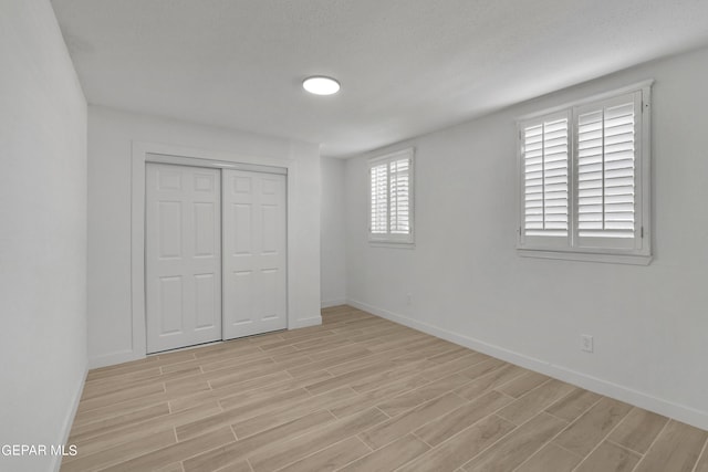1460 Backus St, El Paso, TX 79925 - unfurnished bedroom with light wood-style flooring, baseboards, and a closet