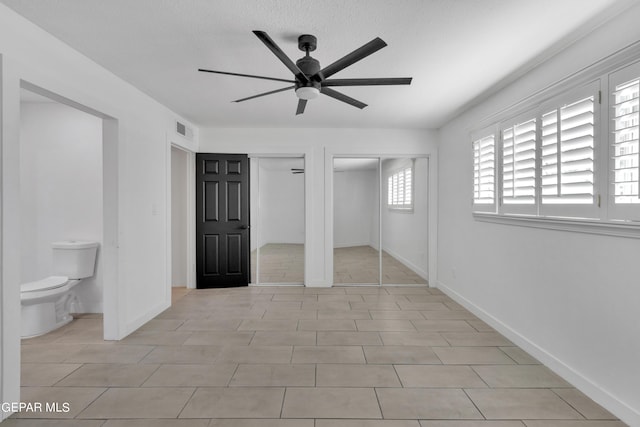 1460 Backus St, El Paso, TX 79925 - unfurnished bedroom with two closets, baseboards, ceiling fan, and ensuite bath