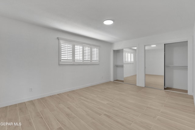 1460 Backus St, El Paso, TX 79925 - unfurnished bedroom with multiple closets, light wood-style floors, and baseboards