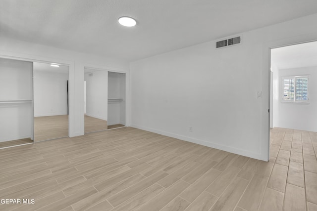 1460 Backus St, El Paso, TX 79925 - unfurnished bedroom with multiple closets, light wood-style floors, and baseboards