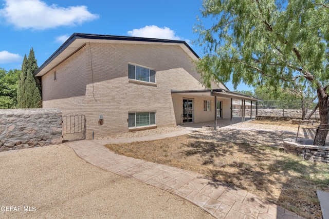 1460 Backus St, El Paso, TX 79925 - back of property featuring brick siding, a patio, and a gate