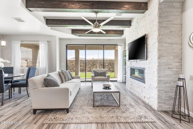 912 Pettus Pl, El Paso, TX 79928 - living area with ceiling fan, wood finished floors, healthy amount of natural light, a stone fireplace, and beamed ceiling