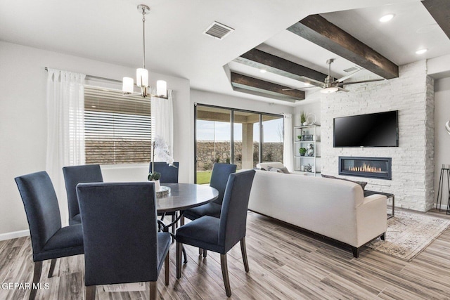 912 Pettus Pl, El Paso, TX 79928 - dining area with ceiling fan, a stone fireplace, a chandelier, wood finished floors, and beam ceiling