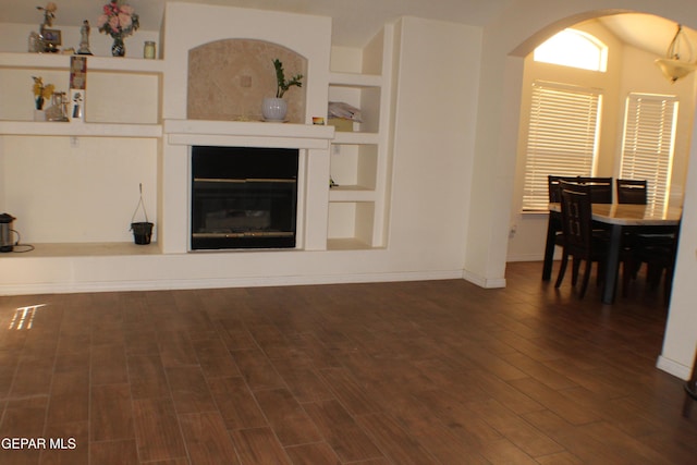 1429 Jettie Ray Way, El Paso, TX 79936 - living room with wood finished floors, arched walkways, a glass covered fireplace, and baseboards