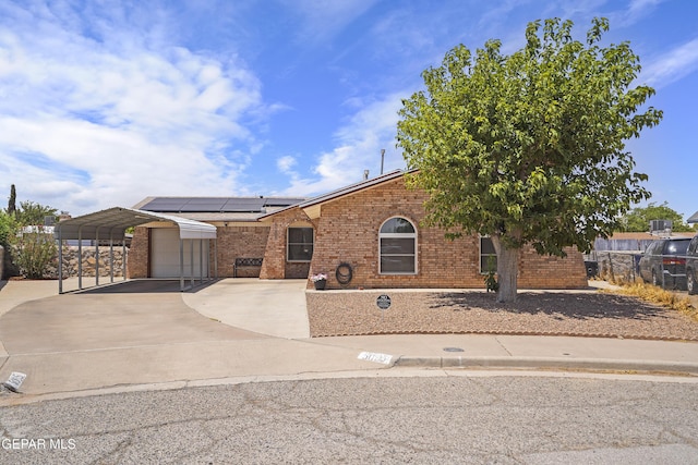 5005 Greco Ct, El Paso, TX 79924 - ranch-style house featuring brick siding, a garage, roof mounted solar panels, and driveway