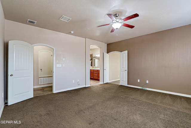 3841 Tierra Campa Dr, El Paso, TX 79938 - unfurnished bedroom with arched walkways, carpet, connected bathroom, and a ceiling fan