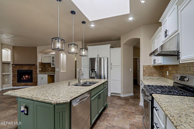 3841 Tierra Campa Dr, El Paso, TX 79938 - kitchen with green cabinetry, appliances with stainless steel finishes, under cabinet range hood, white cabinetry, and open floor plan