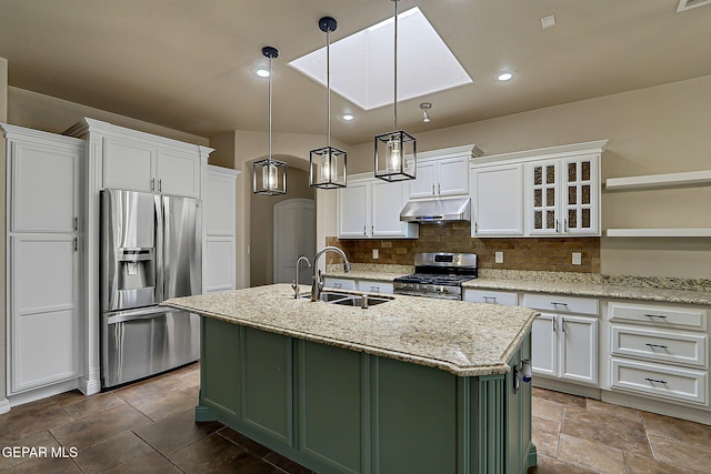 3841 Tierra Campa Dr, El Paso, TX 79938 - kitchen with appliances with stainless steel finishes, under cabinet range hood, white cabinets, decorative backsplash, and a center island with sink