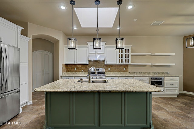 3841 Tierra Campa Dr, El Paso, TX 79938 - kitchen with appliances with stainless steel finishes, under cabinet range hood, green cabinets, tasteful backsplash, and white cabinets