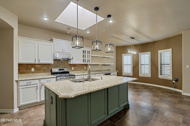 3841 Tierra Campa Dr, El Paso, TX 79938 - kitchen with stainless steel range with gas stovetop, under cabinet range hood, backsplash, white cabinets, and a kitchen island with sink
