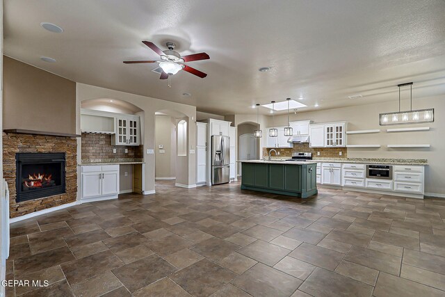 3841 Tierra Campa Dr, El Paso, TX 79938 - kitchen featuring appliances with stainless steel finishes, ceiling fan, tasteful backsplash, arched walkways, and light countertops