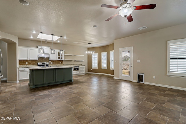 3841 Tierra Campa Dr, El Paso, TX 79938 - kitchen with ceiling fan, plenty of natural light, a center island with sink, and backsplash