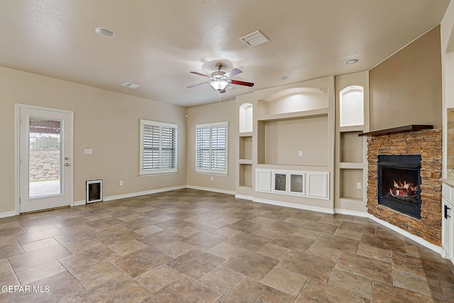 3841 Tierra Campa Dr, El Paso, TX 79938 - unfurnished living room featuring a stone fireplace, a ceiling fan, built in features, recessed lighting, and stone finish floors