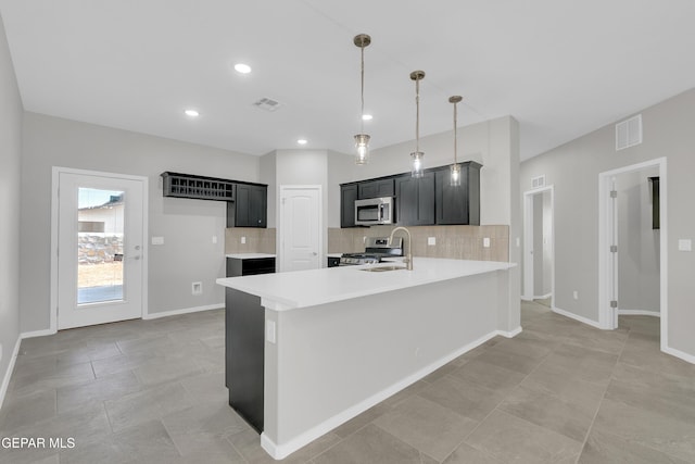 13845 Summer Wave Ave, El Paso, TX 79928 - kitchen with stainless steel appliances, dark cabinets, light countertops, tasteful backsplash, and a peninsula