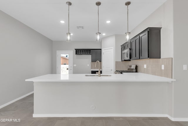 1445 Summer Storm Pl, El Paso, TX 79928 - kitchen featuring stainless steel microwave, range, a sink, light countertops, and a peninsula