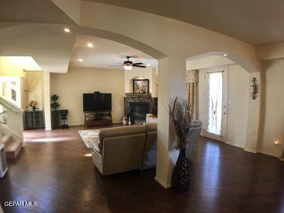 11353 W Ranch Ct NE, El Paso, TX 79934 - living area with arched walkways, wood finished floors, a fireplace, ceiling fan, and recessed lighting