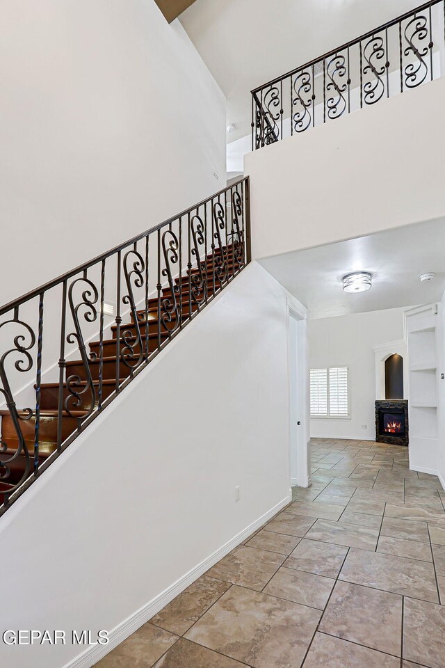 3081 Coyote Point Pl, El Paso, TX 79938 - stairs with a towering ceiling and a glass covered fireplace