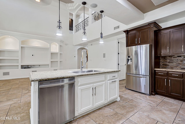 3081 Coyote Point Pl, El Paso, TX 79938 - kitchen with stainless steel appliances, pendant lighting, dark brown cabinetry, backsplash, and a towering ceiling