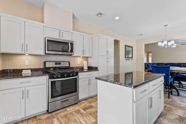 11589 Flor Cadillo, Socorro, TX 79927 - kitchen with stainless steel appliances, a chandelier, dark stone counters, open floor plan, and decorative backsplash