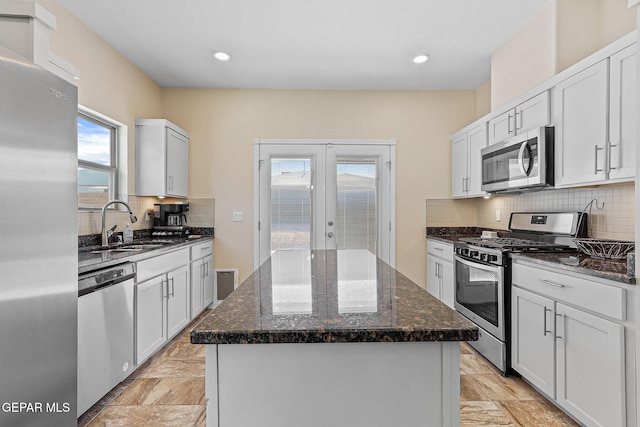 11589 Flor Cadillo, Socorro, TX 79927 - kitchen with stainless steel appliances, a kitchen island, french doors, a sink, and dark stone counters
