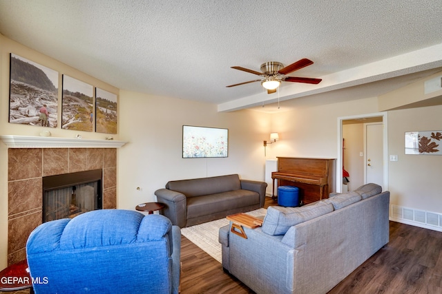 13261 Walker Post Ave, El Paso, TX 79928 - living area with dark wood-type flooring, a ceiling fan, a textured ceiling, a fireplace, and beamed ceiling