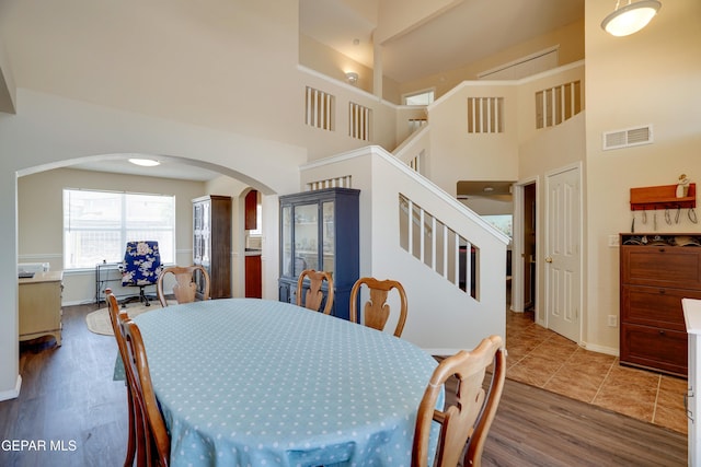 13261 Walker Post Ave, El Paso, TX 79928 - dining space with arched walkways, stairs, a high ceiling, and wood finished floors