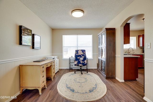 13261 Walker Post Ave, El Paso, TX 79928 - office featuring wood finished floors, arched walkways, and a textured ceiling